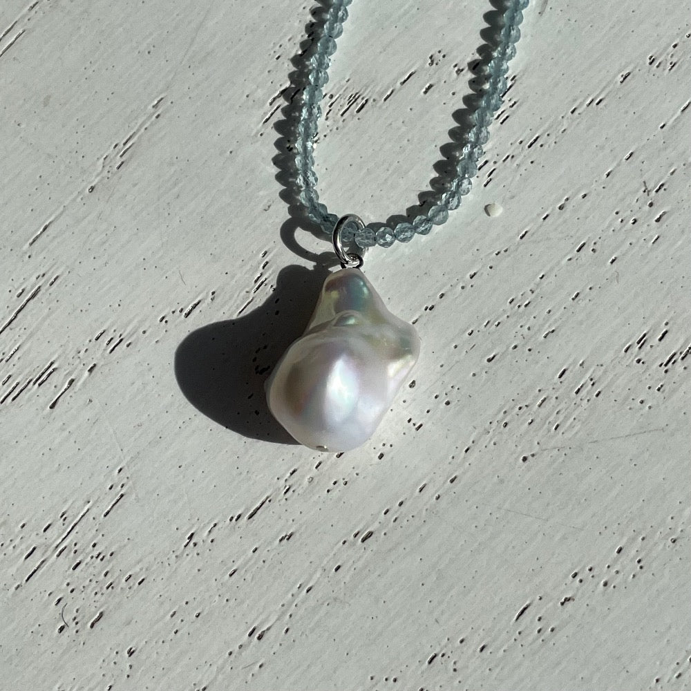 Collier van aquamarijn met barokparel close up