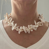 Collier met biwaparels en ei-vormige witte parels op hals met wit t-shirt