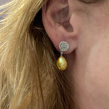 zilveren oorbellen met gele zoetwaterparels in druppelvorm op oor